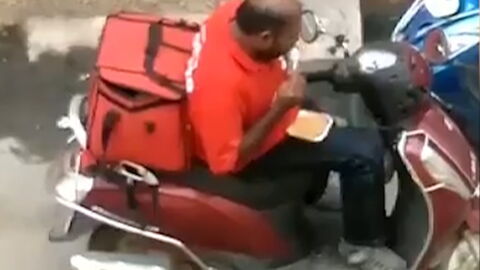 Cheeky delivery driver caught red-handed as he eats customer's food before resealing the box