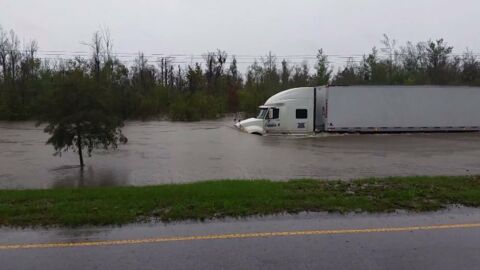 Ce camion roule sur une route inondée