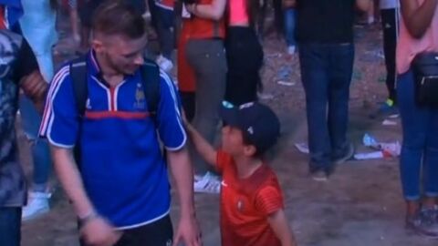 Ein kleiner Junge und Anhänger Portugals tröstet einen französischen Fan