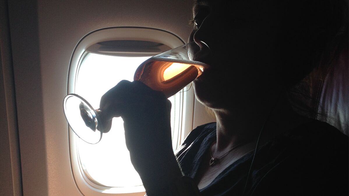 Student in fliege und hosenträgern lehnt alkohol ab. typ in festlichem  outfit hält eine flasche bier in der hand