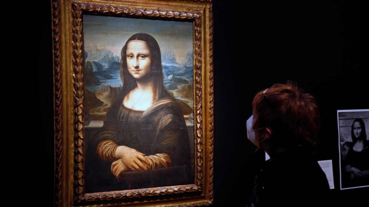 Disguised as an old lady in a wheelchair, a man throws cake at the Mona