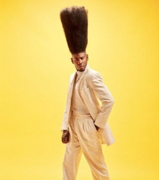 The tallest high top fade in the world goes to Benny Harlem, whose hair reaches nearly 2 feet in the air!