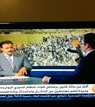 Schrecksekunde: Es sieht so aus, als ob dieser Mann mitten in einer Fernsehsendung mit einer Schusswaffe drohen würde