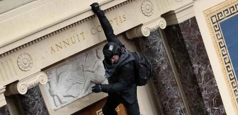 Ein Demonstrant hängt von einem Balkon
