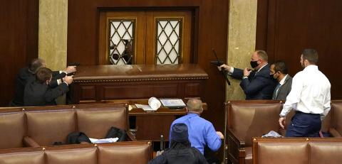 Die Polizisten ziehen ihre Waffen