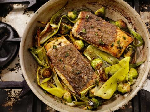 Grilled salmon in a casserole dish on a bed of leeks